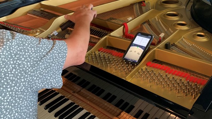 Piano tuner working on a grand piano